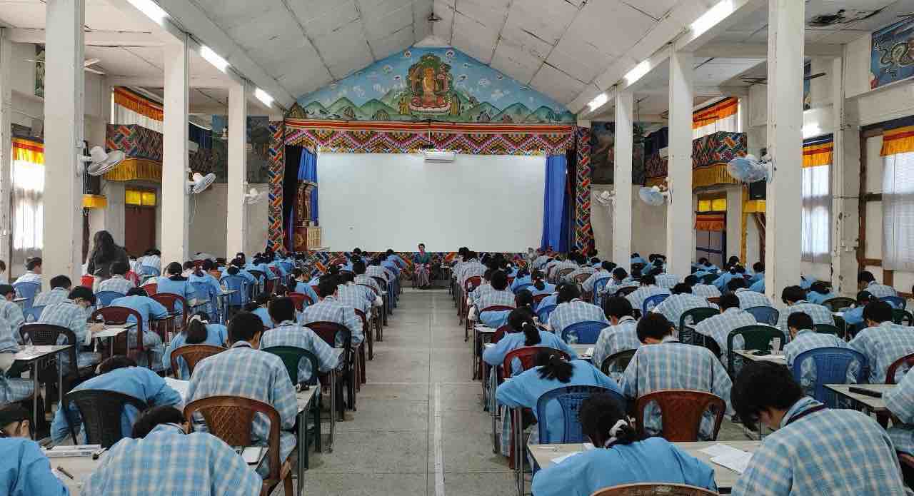 Students seated across an examination hall at PHSS